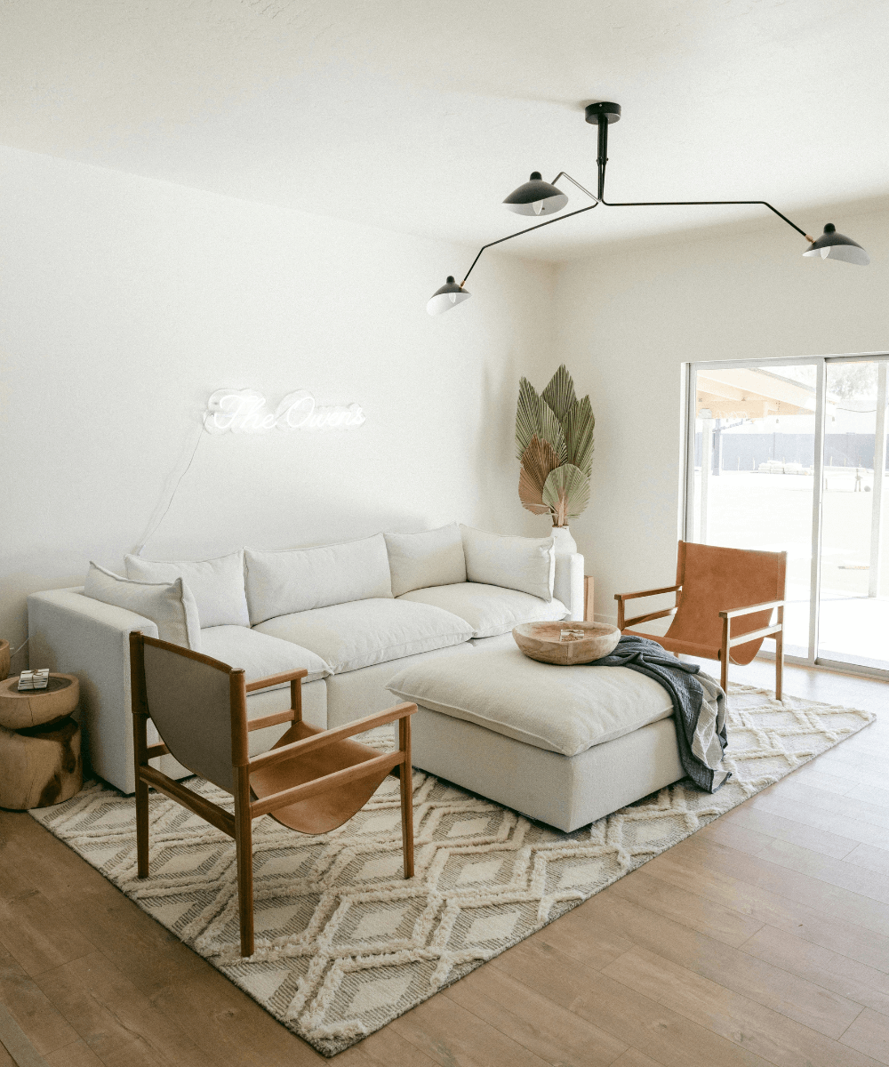 japandi scandinavian minimalist living room with white couch and leather-ish chairs