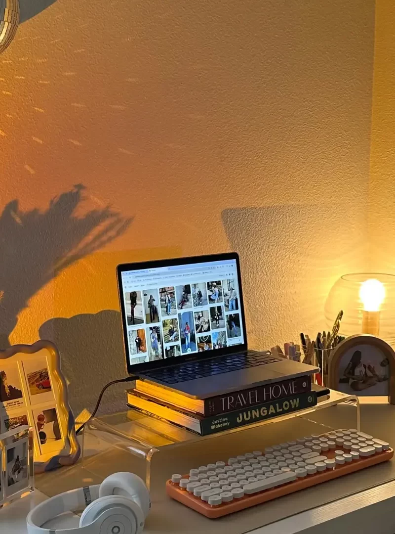 A close-up of a laptop displaying a digital calendar, accompanied by a minimalist headphone stand with over-ear headphones, showcasing a structured and organized work schedule.